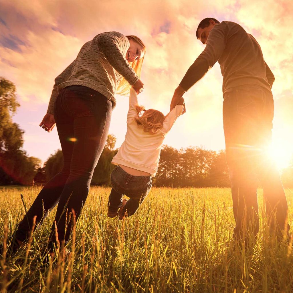 Mom and dad swinging their toddler daughter